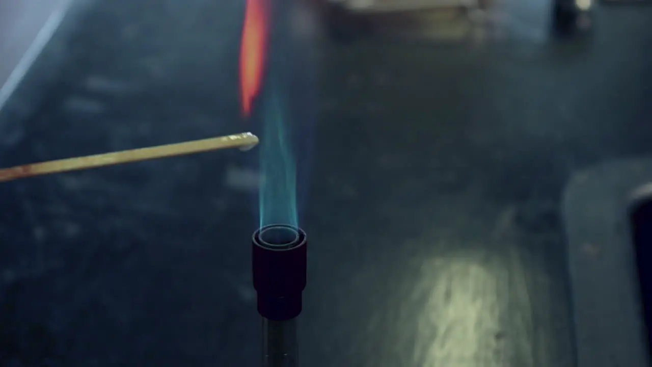 Close up of attempted flame test of clacium ions with too much water on the splint