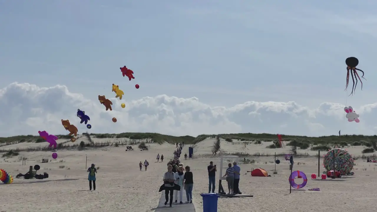 Unusual large kites and balloons with animals and teddybears flying on the beach of Norderney Germany