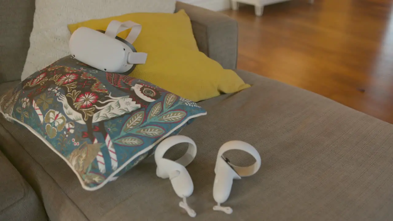 Virtual reality headset and controllers sitting on a couch in a living room