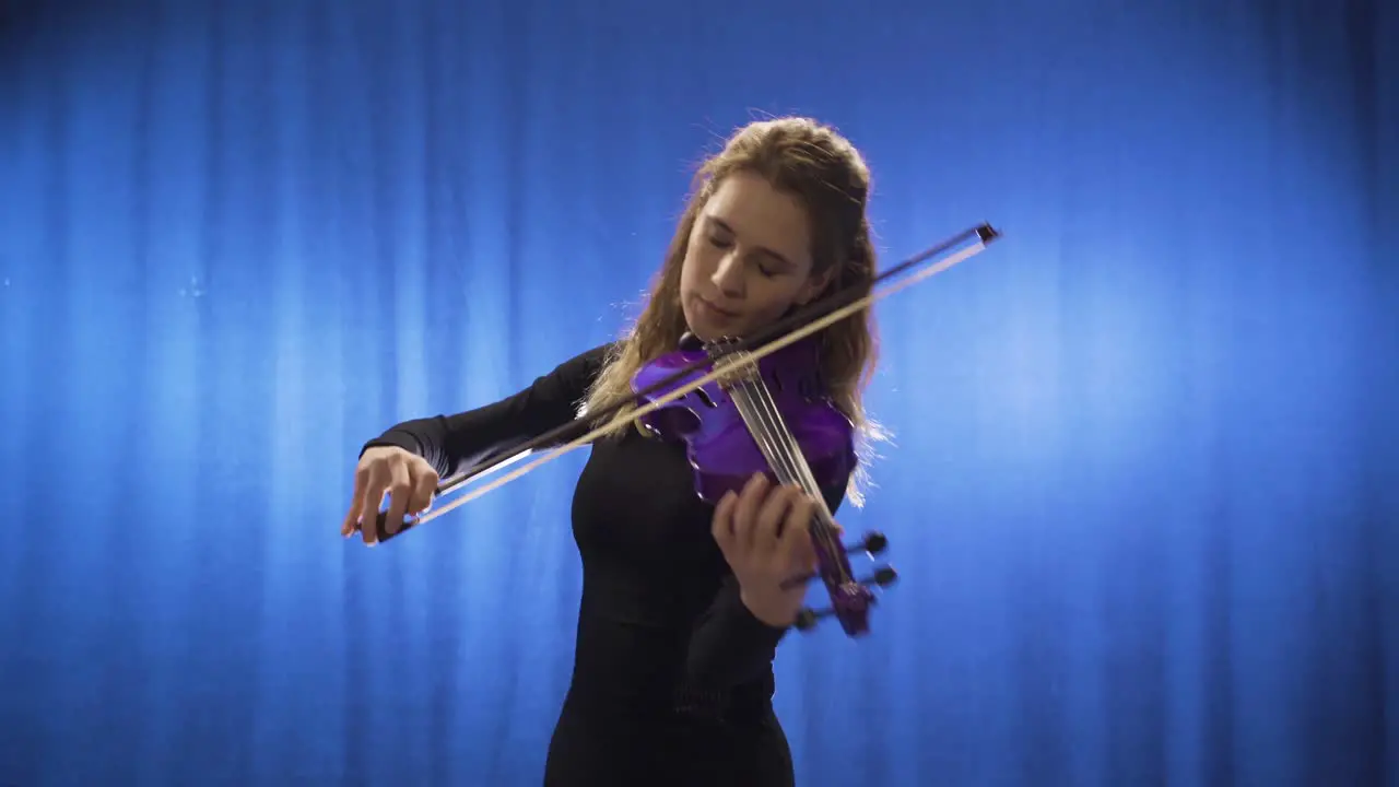 Inspirational talented musician woman playing violin on stage and happy