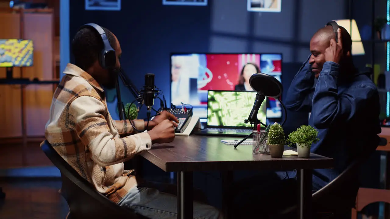 Cheerful guest fist bumping and saluting online comedy show presenter