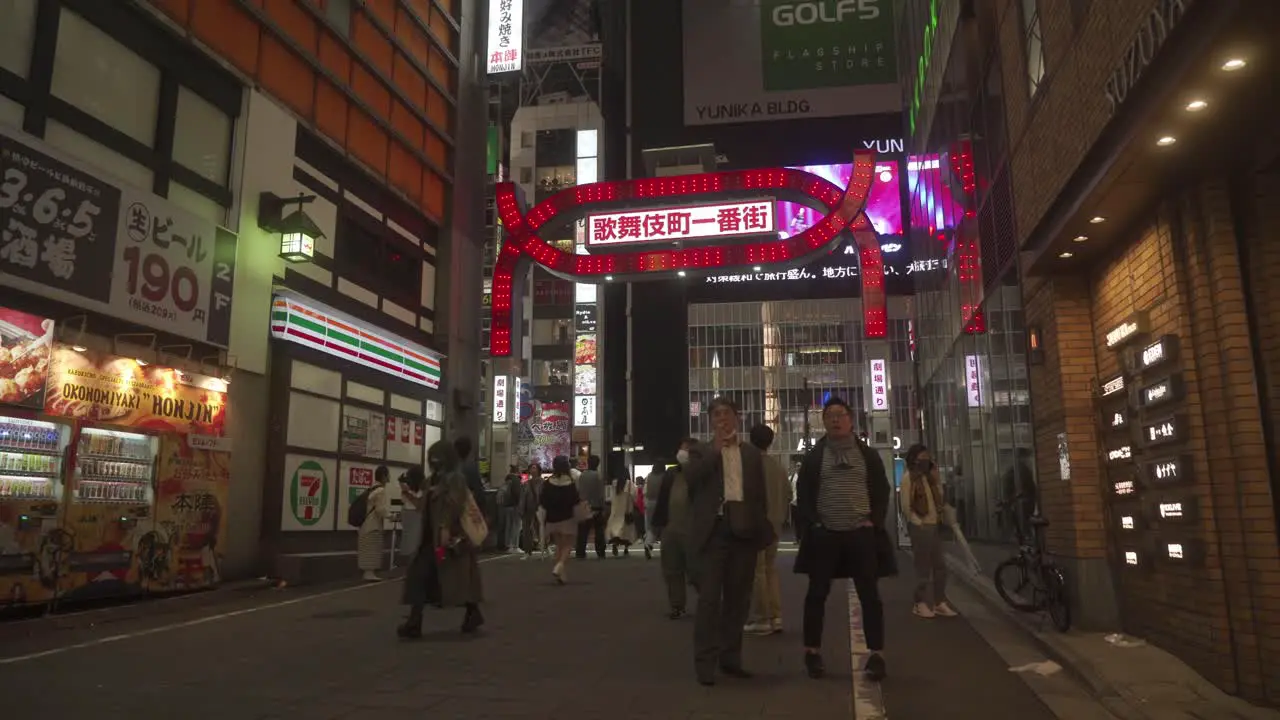 People walking at night through Kabukicho Japan's main red light district in Tokyo neon signs and nightlife