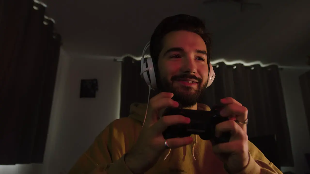 Male gaming with a game pad smiling and laughing