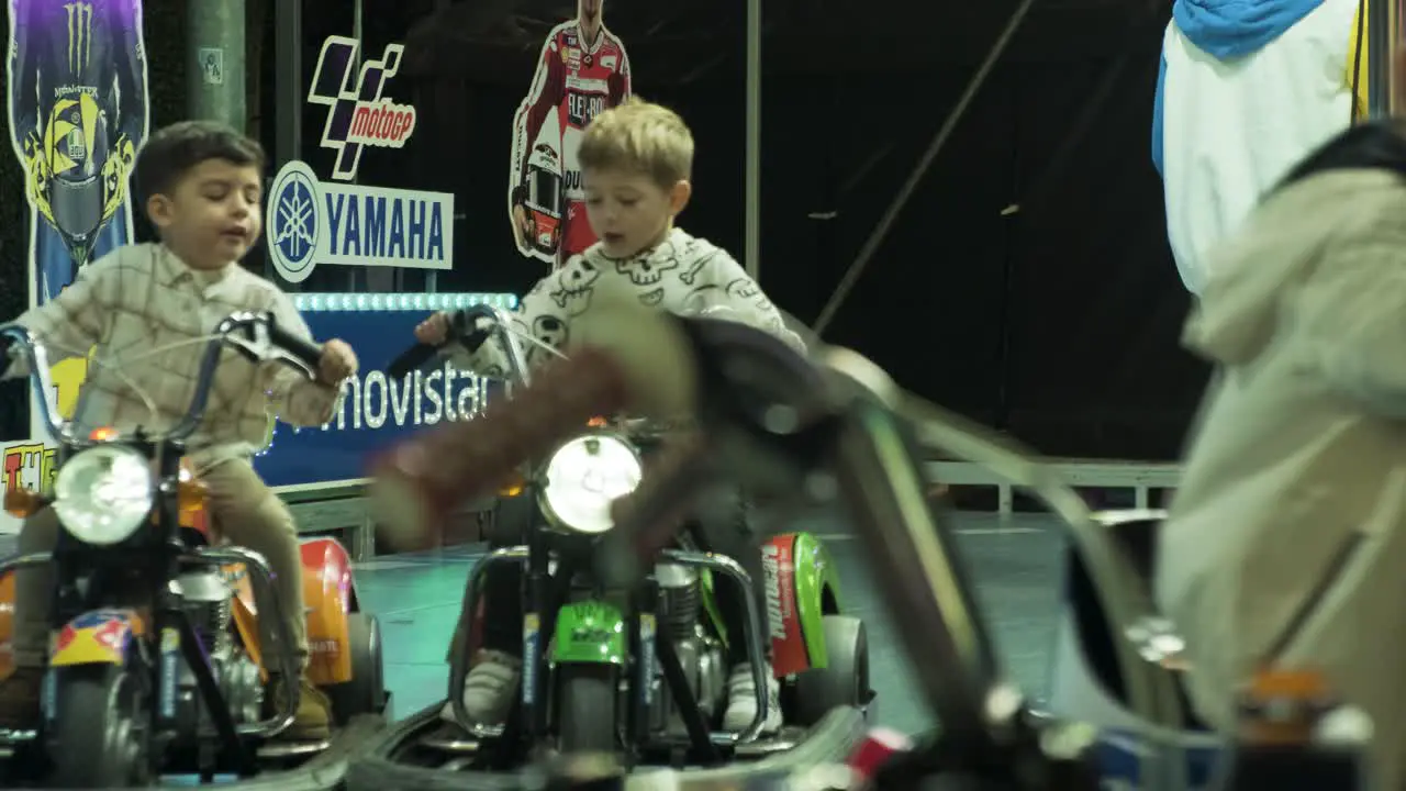 Small kids having fun riding bumper cars at San Froilan carnival lugo Nighttime