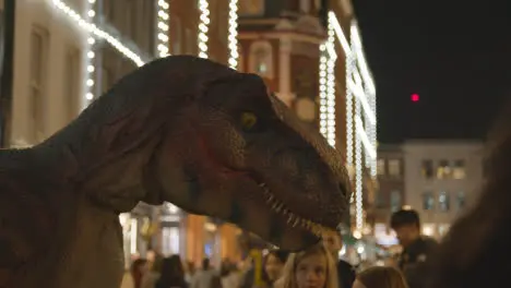 Street Performer Operating Model Dinosaur In Covent Garden London UK At Night 2