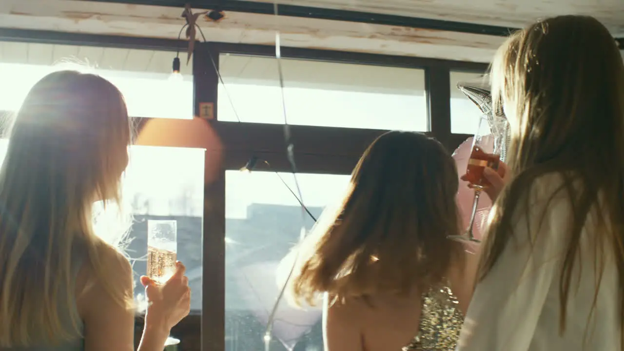 Three Young Women In Party Dresses Toasting With Champagne