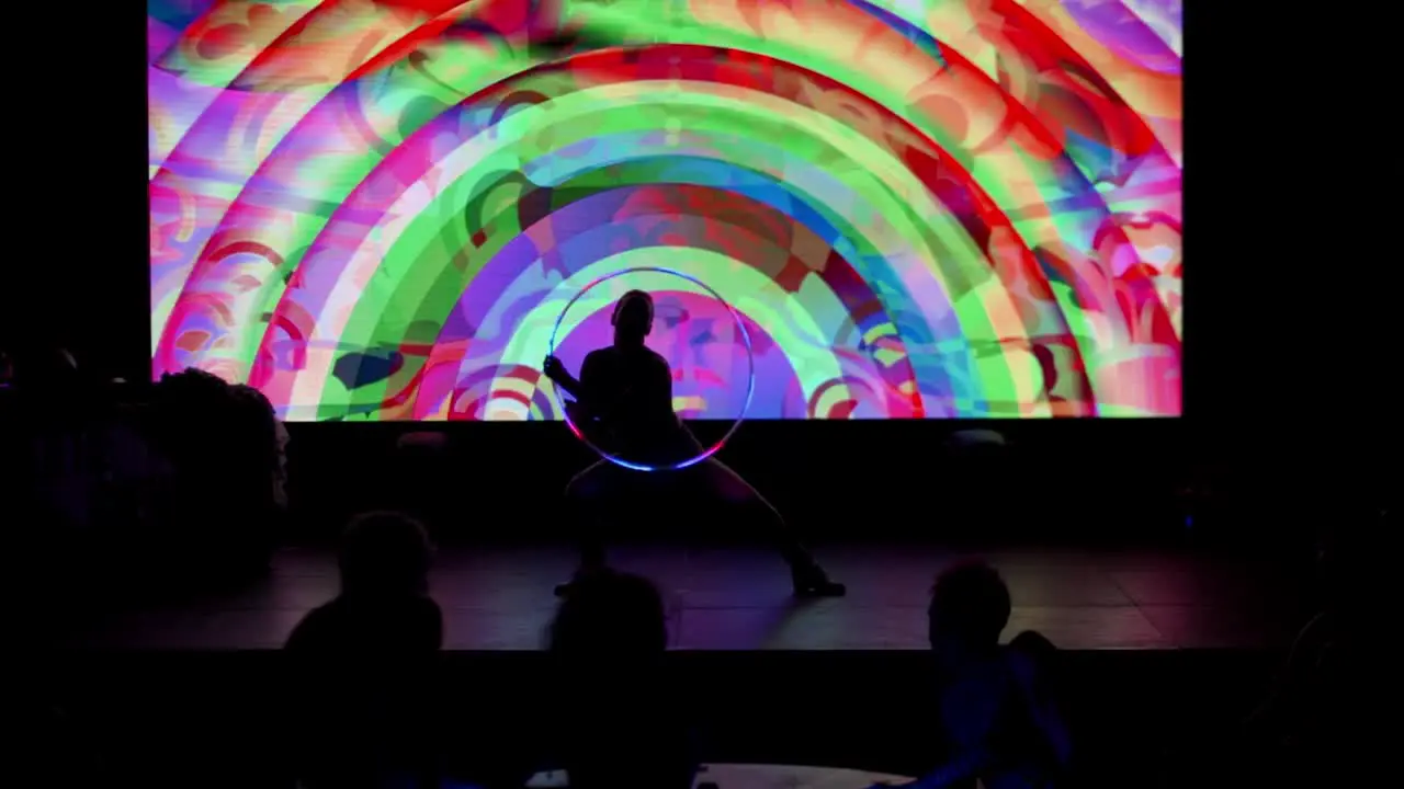 Dancer with glowing ring performing on the stage in a nightclub