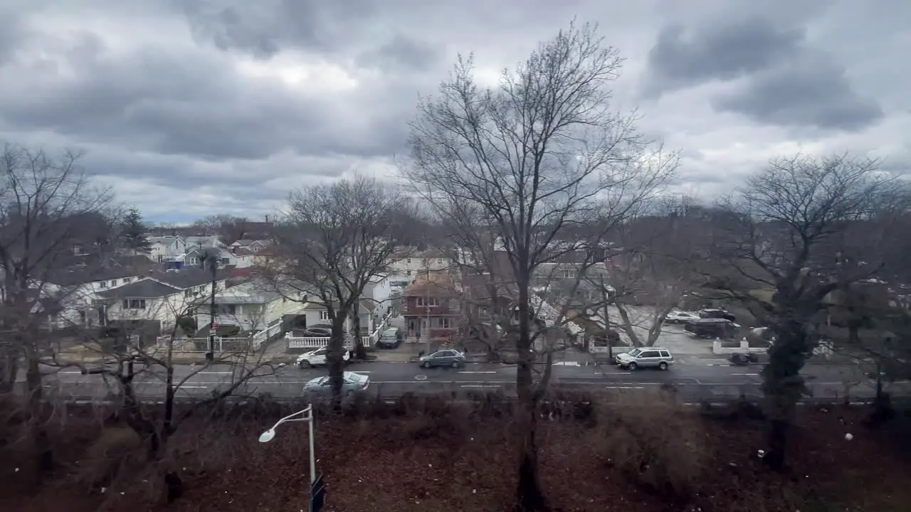 slow motion shot of new york city subway running through the streets of the kew gardens neighborhood in brooklyn