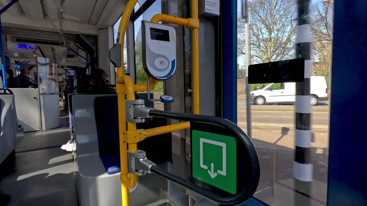 A view looking out of the door window of a public tram traveling into the city of Amsterdam Netherlands