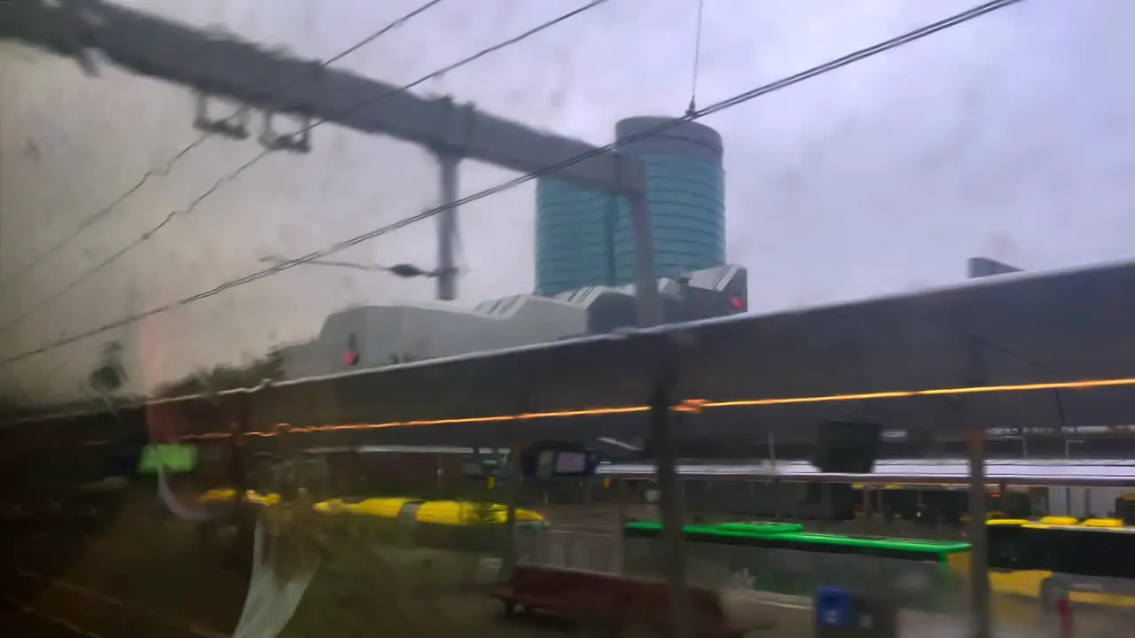 POV through rainy train window arriving at Utrecht Central station