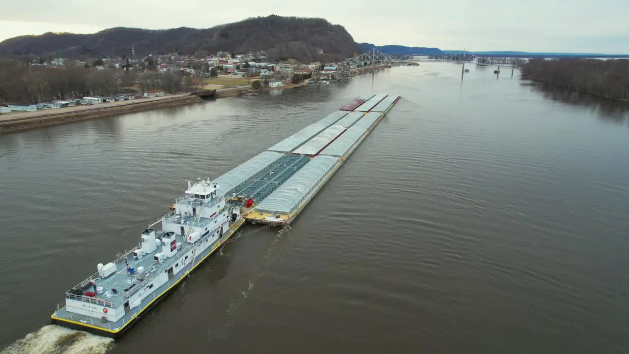 A towboat pushing barges north on the Mississippi River approaches the Black Hawk Bridge at Lansing Iowa-2