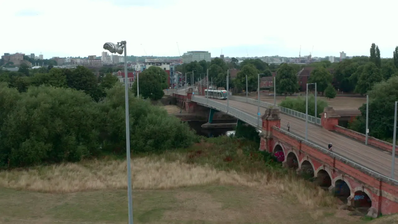 Descending drone shot of Nottingham tram over river Trent Wilford toll bridge