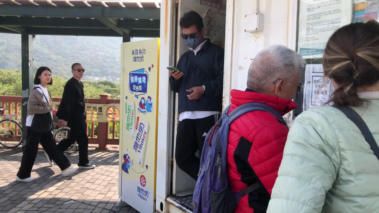 Bus conductor counts people leaving the bus from Ngong Ping Village as they depart in Tai O Hong Kong