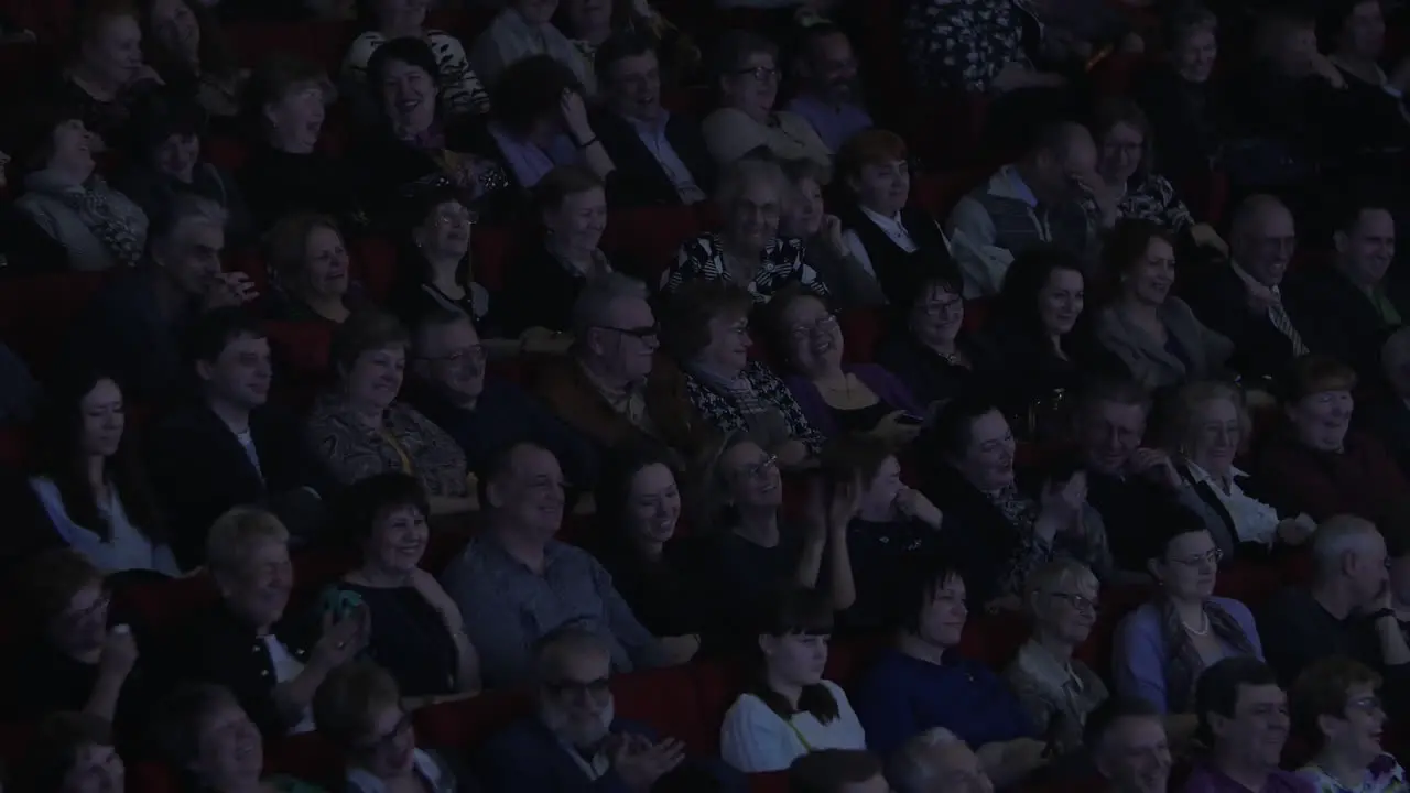 Viewers in movie hall laughing at film