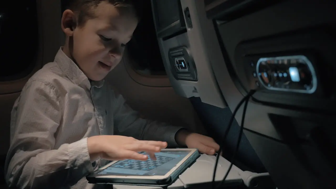 Boy with pad in plane He entertaining with chess game