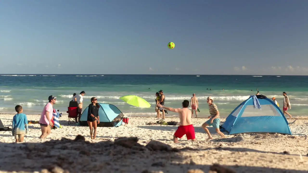 Family enjoying sunny summer day on mexican beach playing volleyball