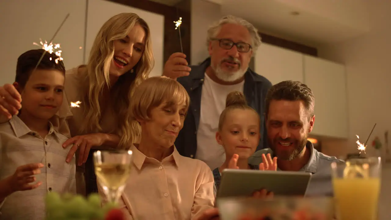 Positive family singing christmas song during online video chat on tablet