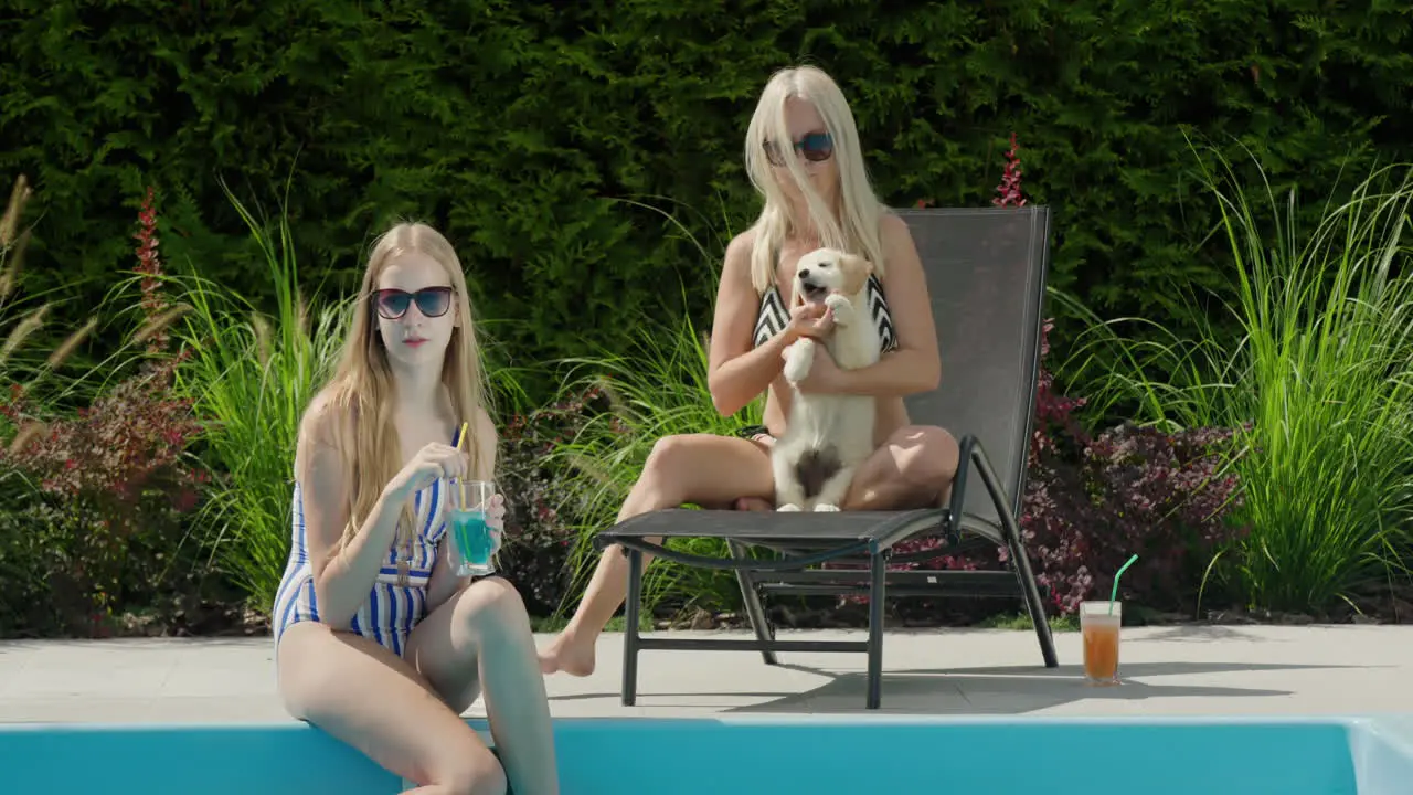 Mom daughter and puppy are relaxing by the pool Good time together family vacation