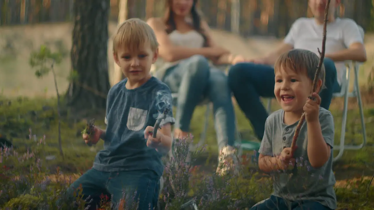 Children sit by the fire and look at the fire playing with sticks