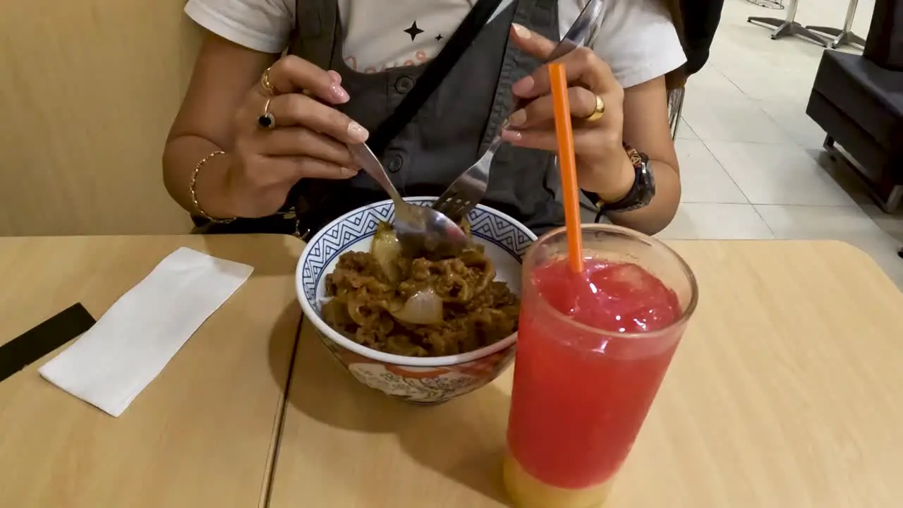 Unrecognizable woman eat Japanese food in restaurant in Yogyakarta Indonesia