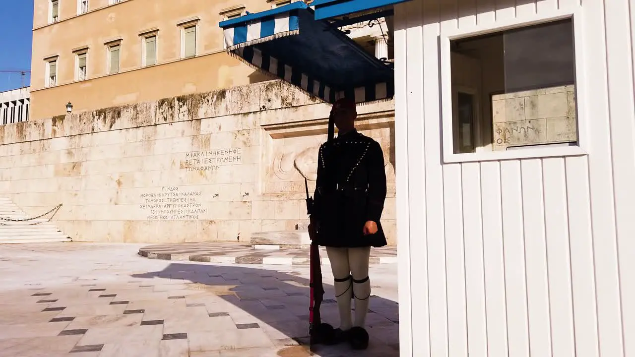 Greek presidential guard with traditional military uniform evzone is preparing for the ceremonial guard change in front of the Hellenic Parliament while holding red rifle