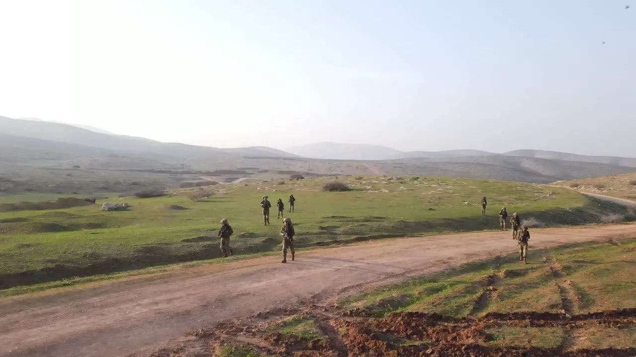 Soldiers walking on large open field aerial view