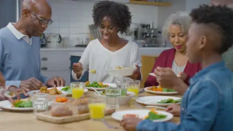 Family Start Plating Up Dinner Together at Dining Table 