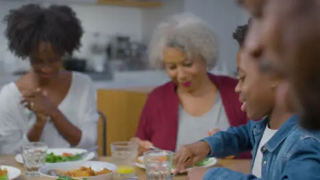 Family Talking and Laughing Whilst Having Evening Meal Together