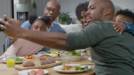 Family Taking Selfie Together During Evening Meal 