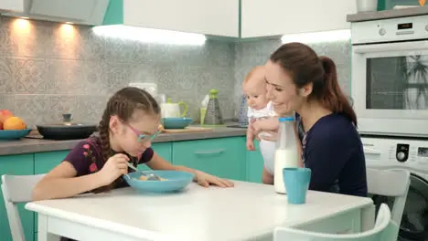 Family breakfast at morning Girl eating corn flakes with milk at kitchen table