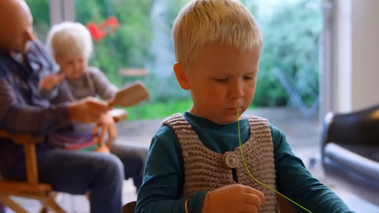 Boy holding thread and sewing needle at home 4k