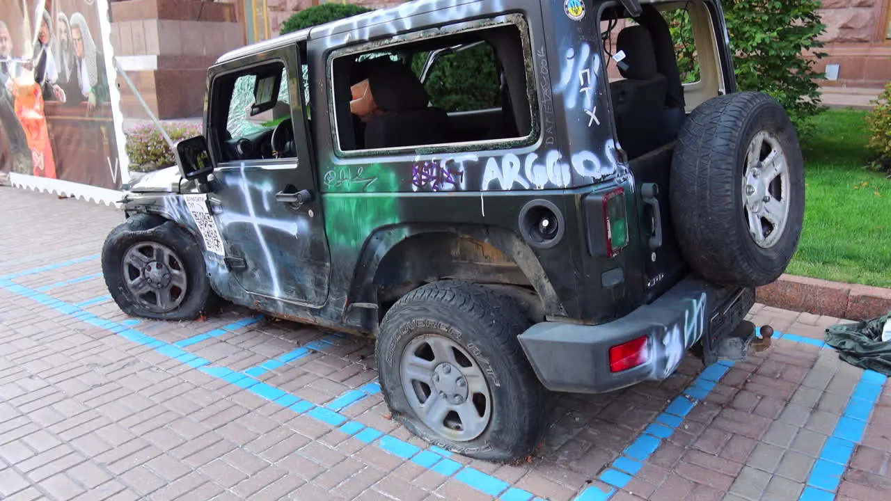 Shelled black jeep car on Khreshchatyk main street from the Russia Ukraine war in Kyiv city center destroyed broken war vehicle in Ukraine damaged car 4K shot