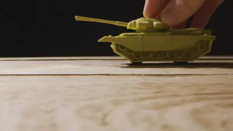 Close Up Shot of Toy Tank Rolling Through Frame