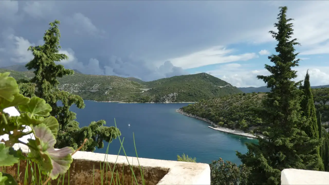 Timelapse showing clouds over the mountains and movement of the small boats in Slano Bay Croatia