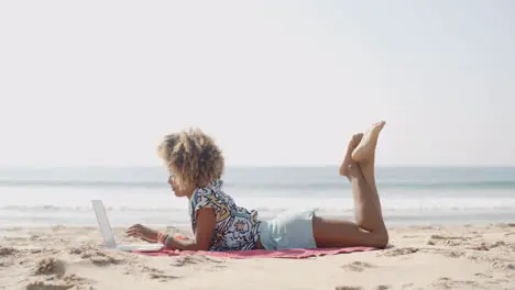 Happy Woman Typing On A Laptop On A Beach