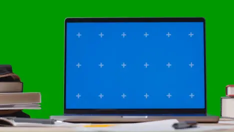 Blue Screen Laptop With Books On Table With Green Screen Background Education Concept 1