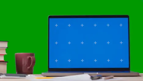 Blue Screen Laptop With Books On Table With Green Screen Background 3