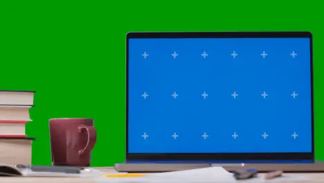 Blue Screen Laptop With Books On Table With Green Screen Background 2