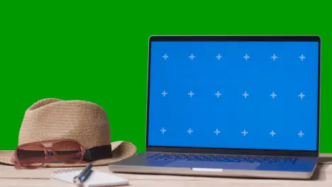 Blue Screen Laptop On Table With Holiday Accessories And Green Screen Background 2