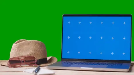 Blue Screen Laptop On Table With Holiday Accessories And Green Screen Background 3