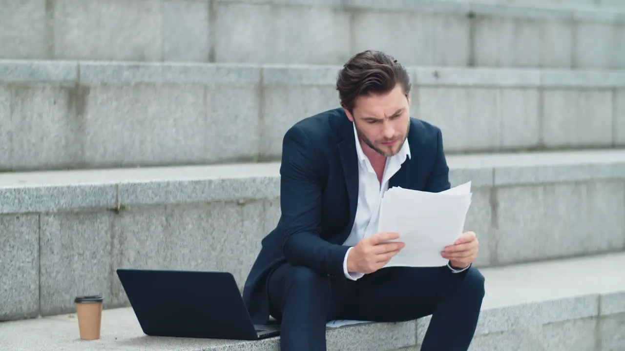 Businessman thinking about financial documents on street Man reading documents