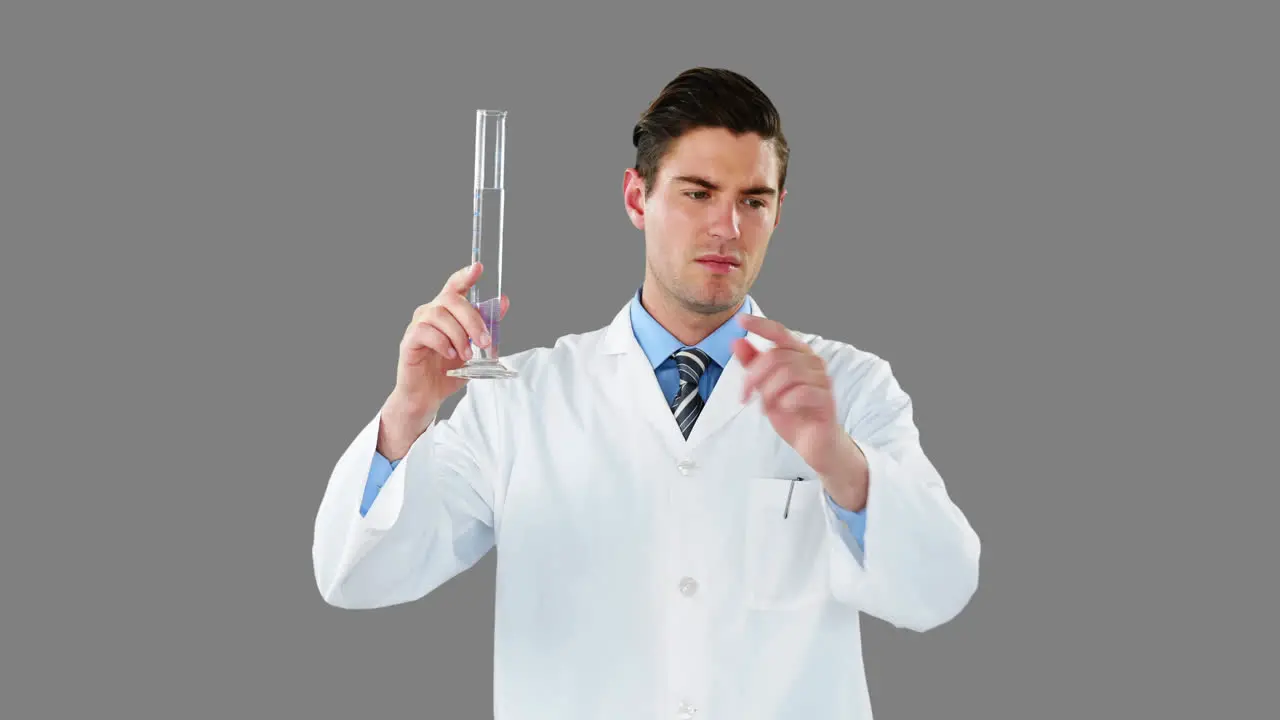 Doctor using digital screen while examining chemical in test tube