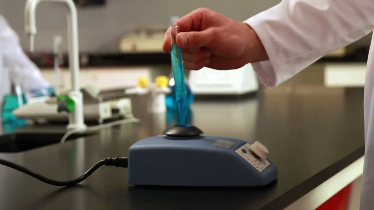 Scientist mixing test tube with centrifuge