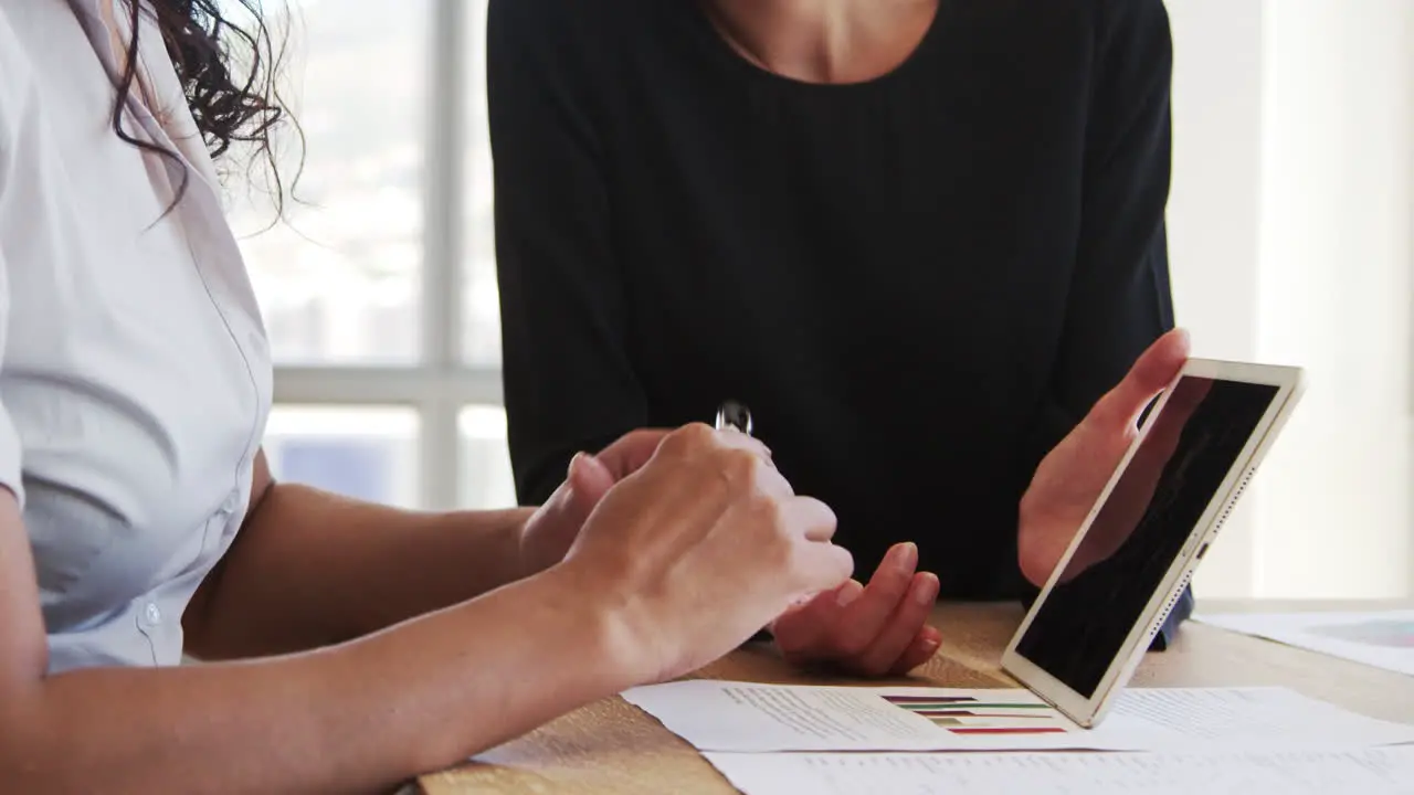 Close Up Of Businesswomen Using Digital Tablet In Meeting