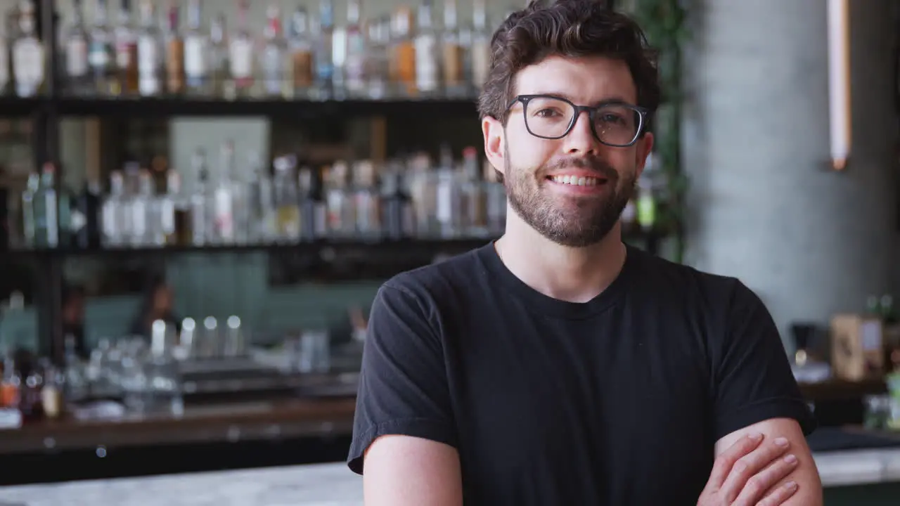 Portrait Of Confident Male Owner Of Restaurant Bar Standing Inside By Counter