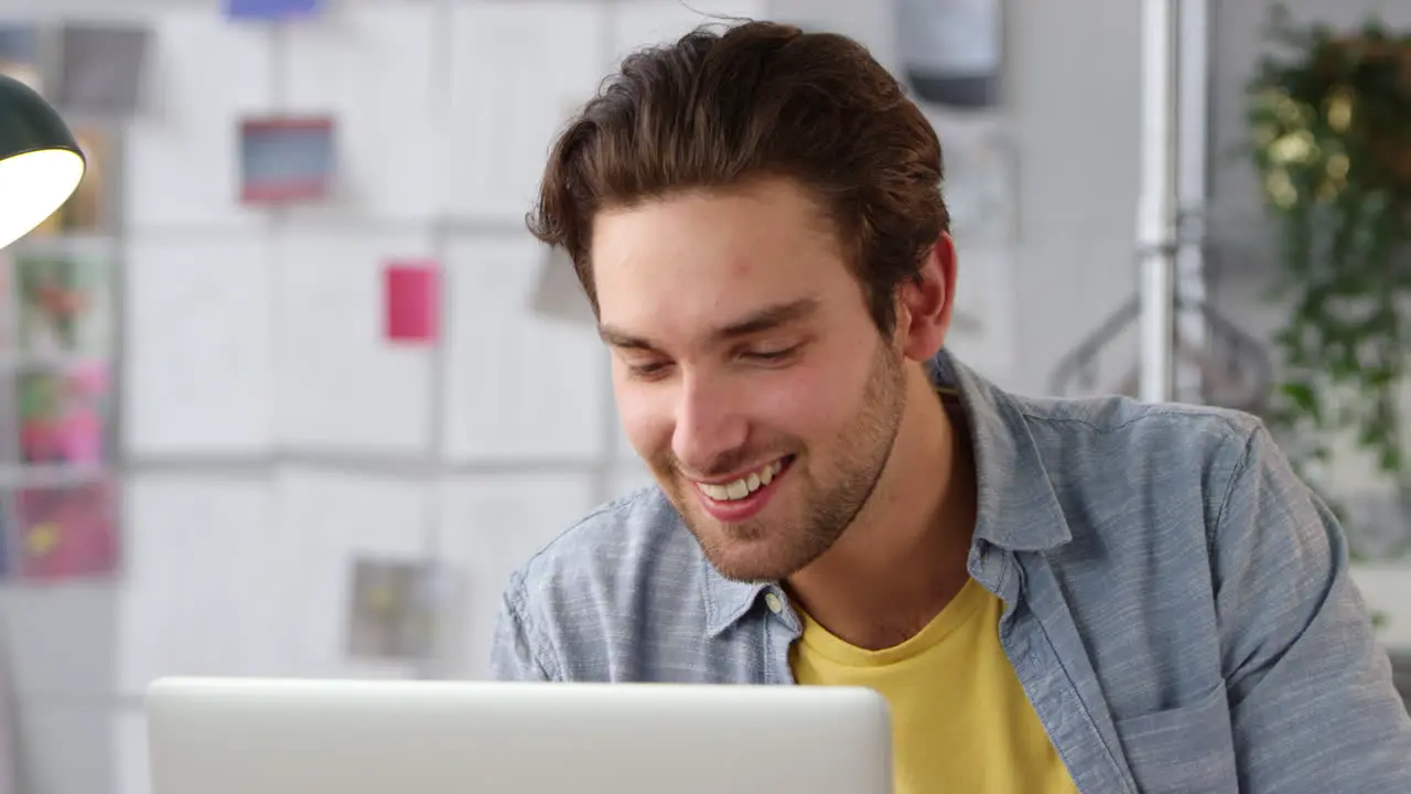 Close Up Of Male Student Or Business Owner Working In Fashion Using Laptop In Studio