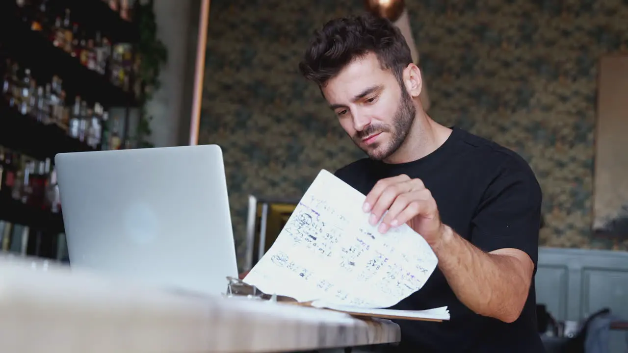 Male Owner Of Restaurant Bar Sitting With Laptop At Counter Working