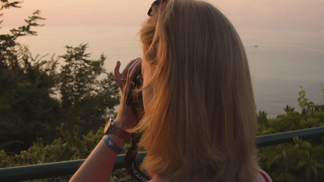 Woman taking pictures from ocean-beach evening slow motion