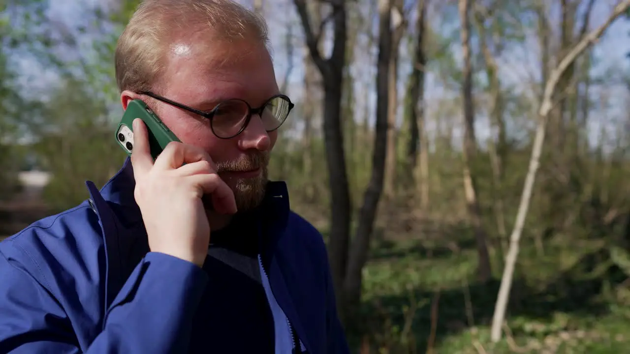 Man Receives a Phone Call Walking in Forest Mediun Shot from Front