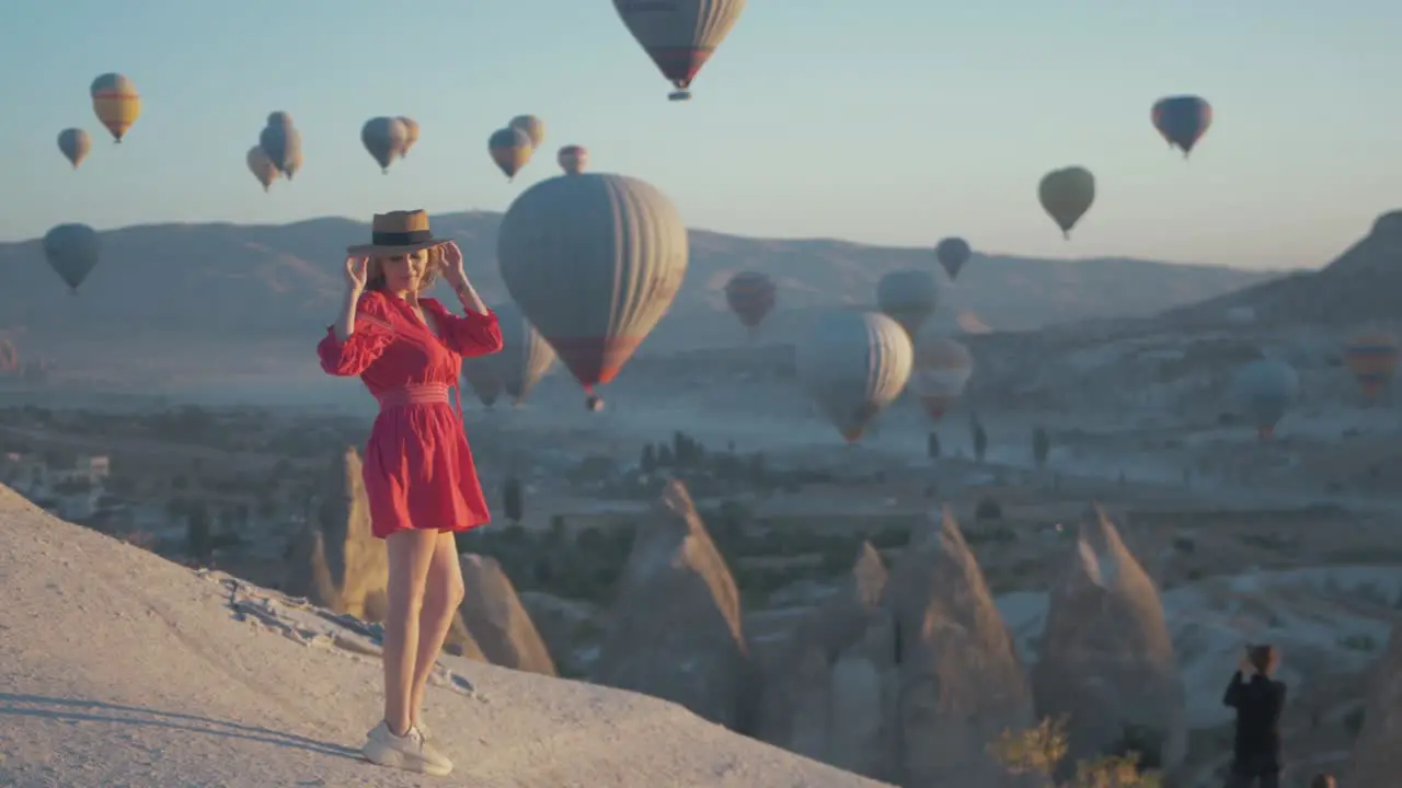 Attractive woman in dress posing with hot air balloons Cappadocia